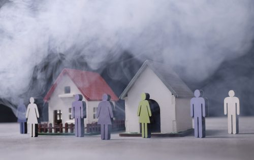 Image de personnages devant des maisons polluées