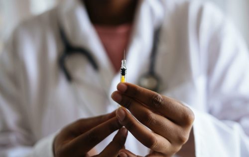 Image d'un personnel médical tenant une seringue à la main